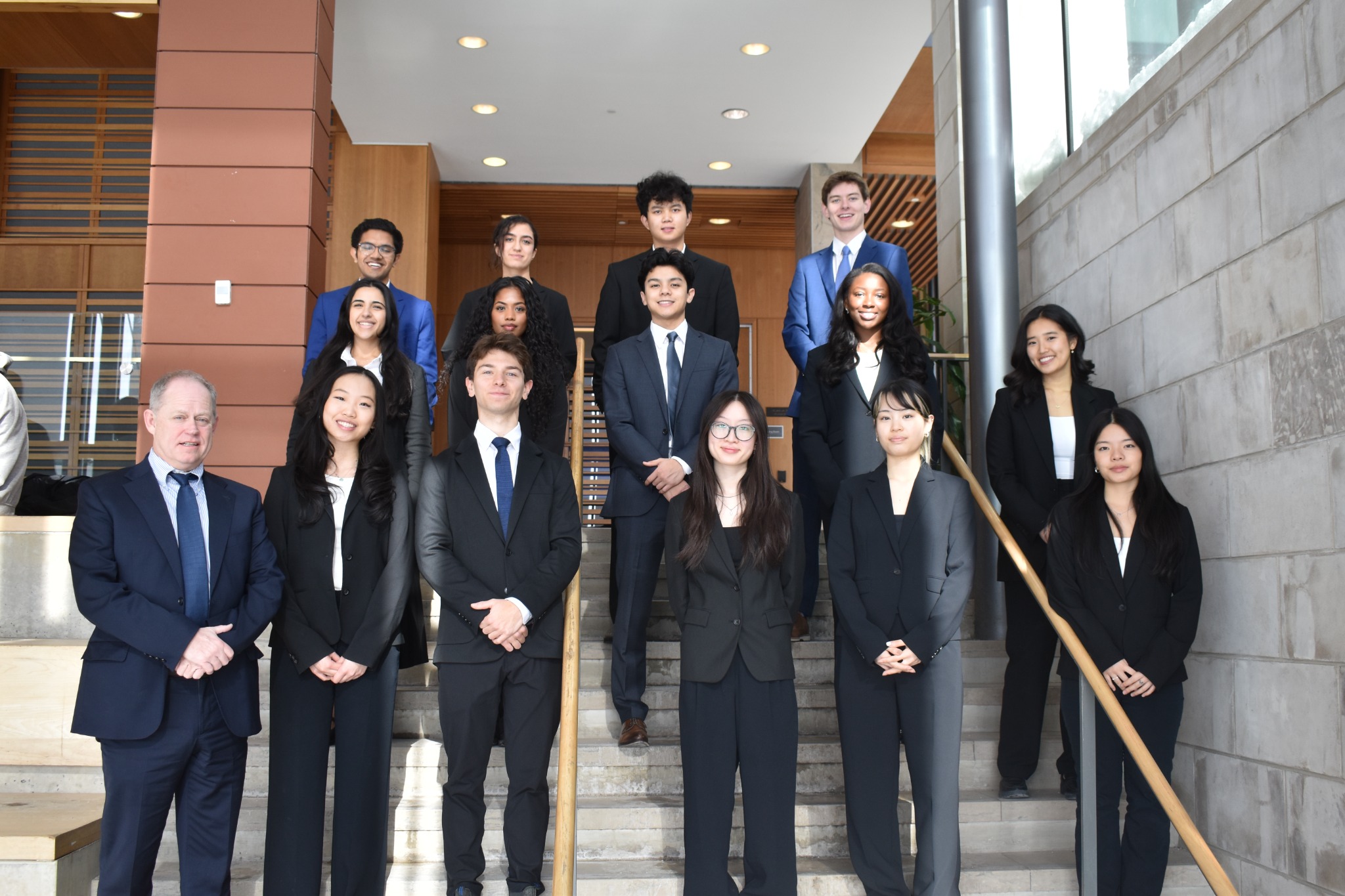 A student leadership team in formal attire inside a campus building